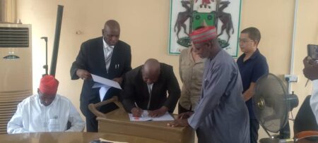 Barr. Haruna Isa Dederi while signing the contract